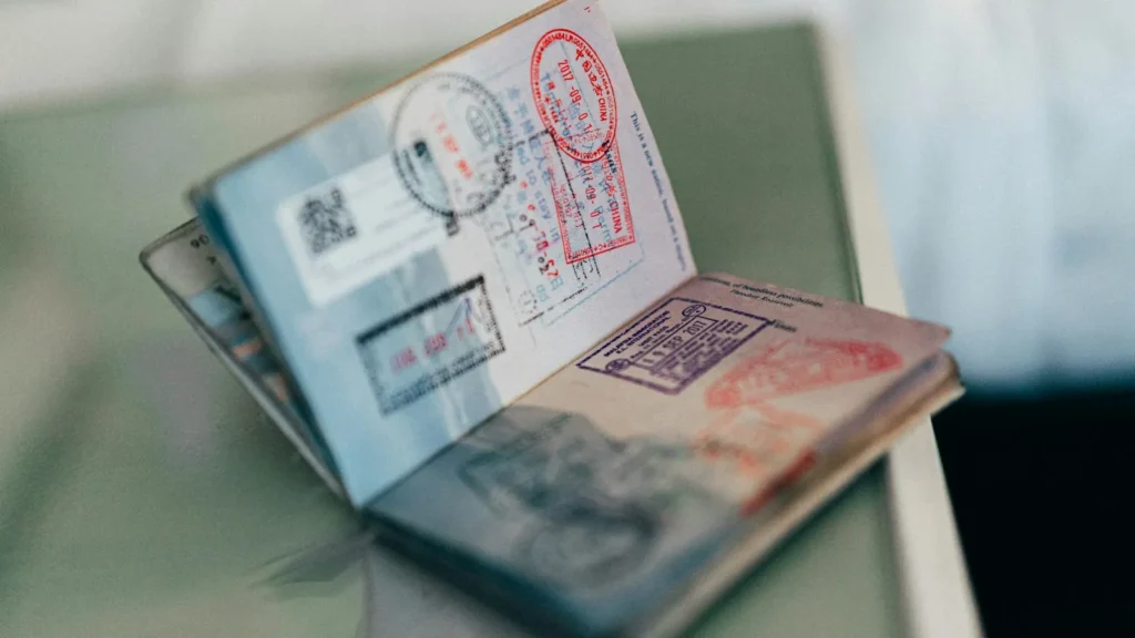 Passport, boarding pass and travel documents laid out on a suitcase as part of an international travel checklist